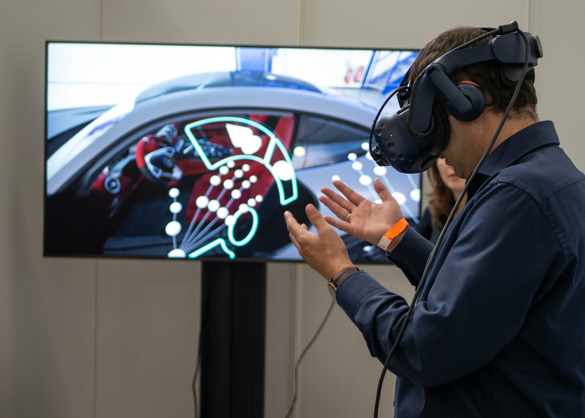 Man using a virtual reality headset with a car dashboard simulation displayed on the screen.